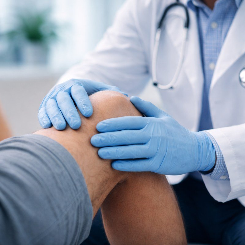 Ortopedista valorando la rodilla de un paciente en consulta en Punta de Mita